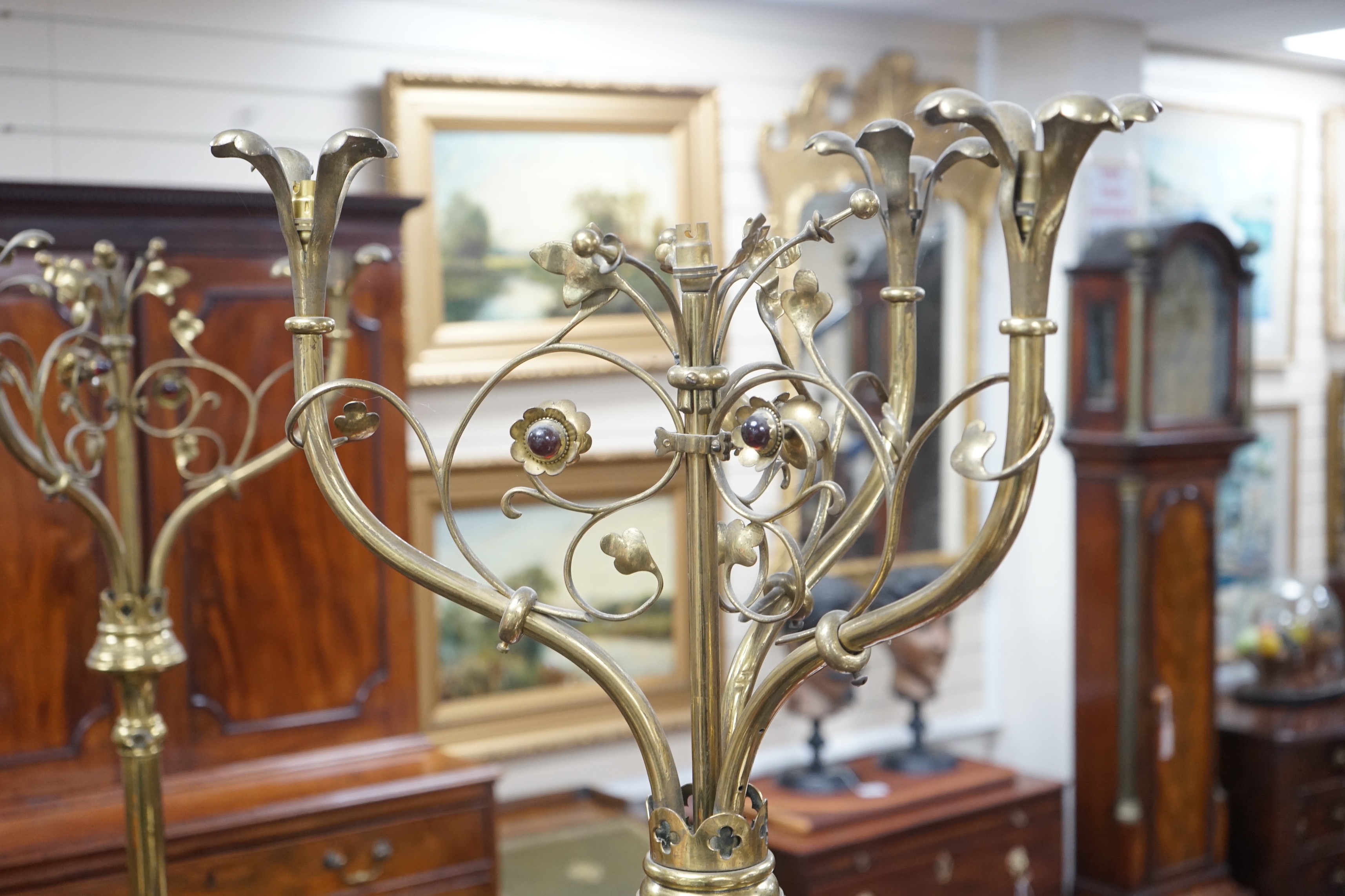 A pair of Victorian Gothic brass ecclesiastical three branch floor lamps, converted to electricity, height 195cm